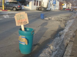 trash bin with cardboard sign reading "Slow Down Potholes Stop Sign" on Bound Brook Road Dunellen, February 23, 2014